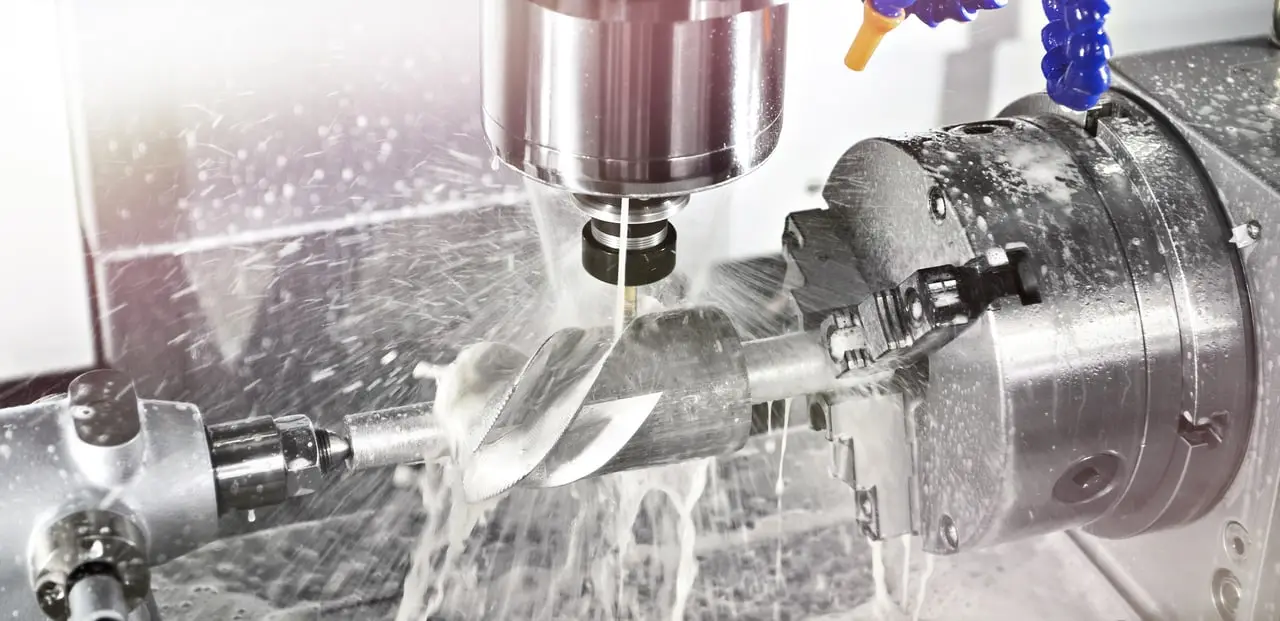 CNC-Fräsmaschine bei der Bearbeitung eines Werkstücks mit Kühlschmierstoff